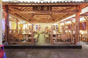 Una estructura de madera tradicional con mesas y sillas dispuestas para comer.