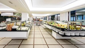 Tilava buffetalue, jossa on useita ruokapisteitä, siisti laattalattia sekä valoisa ja hyvin valaistu ympäristö.