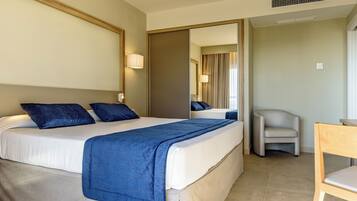 A hotel room with a bed, a chair, and a desk.
