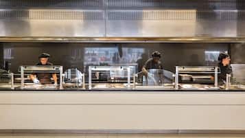 Una cocina comercial con electrodomésticos de acero inoxidable y suelo de baldosas.