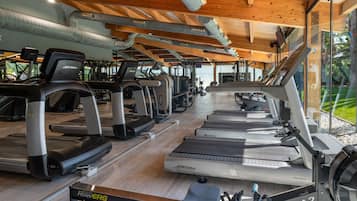 A gym with multiple treadmills, stationary bikes, and rowing machines.