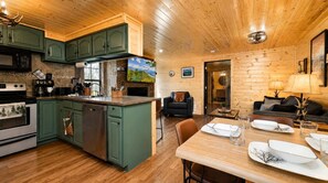 A modern kitchen with green cabinets, a built-in microwave, and a dishwasher. - Mountain Views at Dolly's Castle Unit 5 (Sevierville)