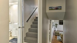 A staircase leading to a landing with a painting of a red truck on the wall. - The Harold House  (Olathe)
