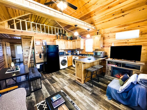 A cozy cabin interior with a kitchen, dining area, and living room. - Cabin #1•1 mi to DeGray Lake (Bismarck)