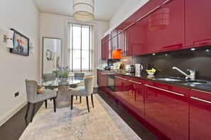 Enjoy meals in this kitchen with a central island and seating area, featuring a window, light fixture, and framed picture.