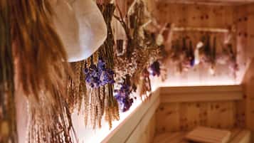 A room with wooden walls and a window with dried flowers and wheat.