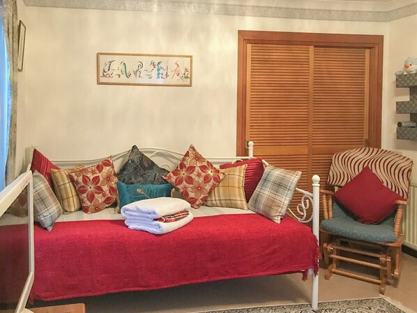 A cozy room with a bed, a wooden chair, and a wooden door.