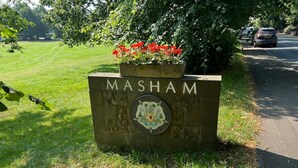 Une enseigne portant le nom « MASHAM » et un blason.