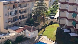 A residential area with a swimming pool, multi-story buildings, and a clear view of the sea. - Cozy apartment with pool (Nerja)