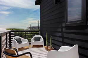 A balcony with two white chairs, a wooden chair, and three potted cacti. - 5 Min from Moody - Austin's Eastside Gem (Austin)