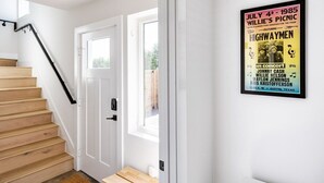 Un escalier menant à une porte sur laquelle est affichée une affiche annonçant un concert.