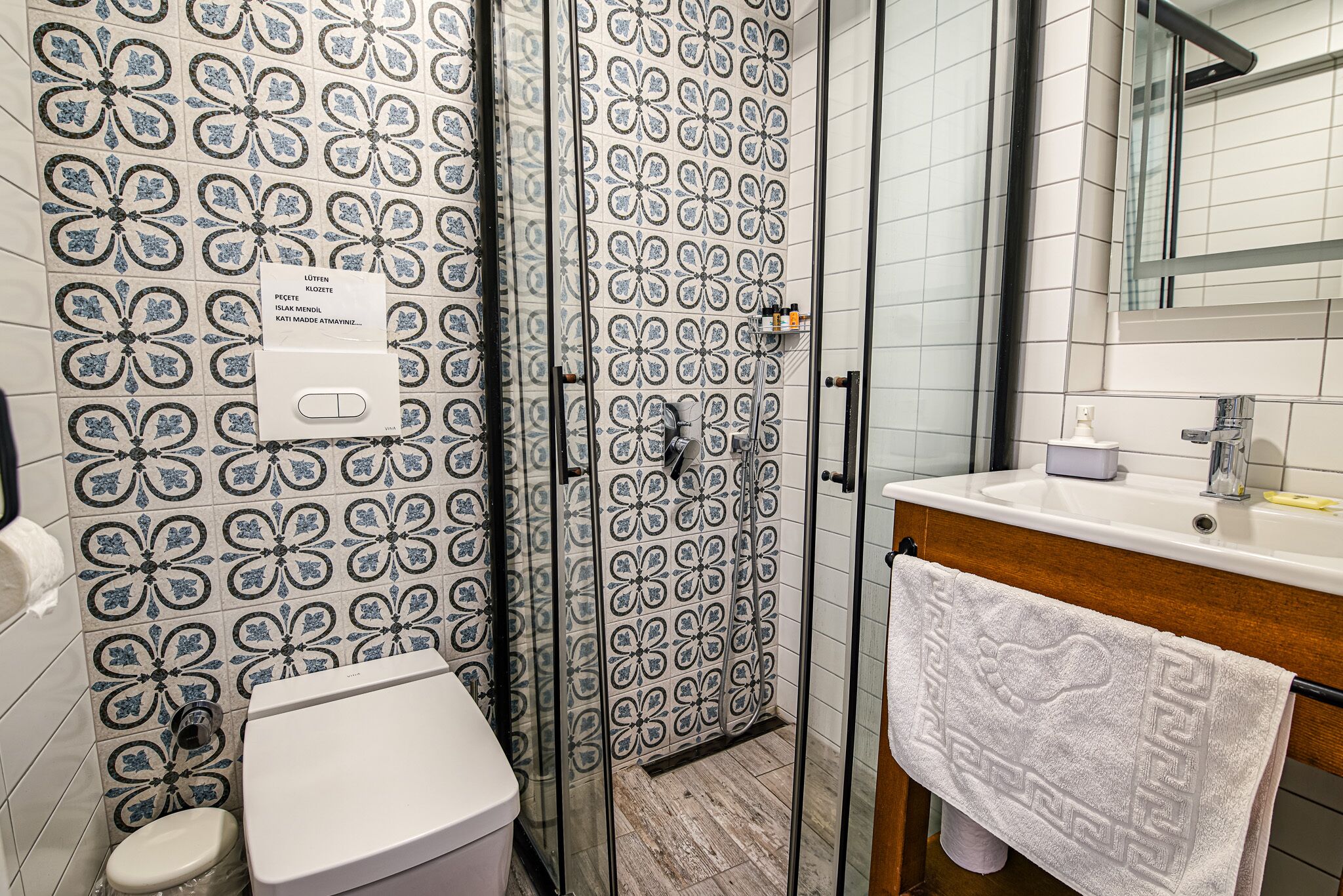 A bathroom with a shower, toilet, and sink.