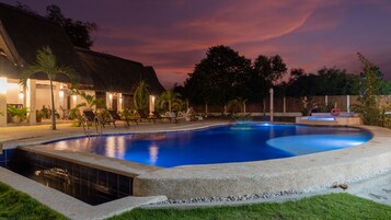 Una piscina al aire libre, sillones reclinables de piscina
