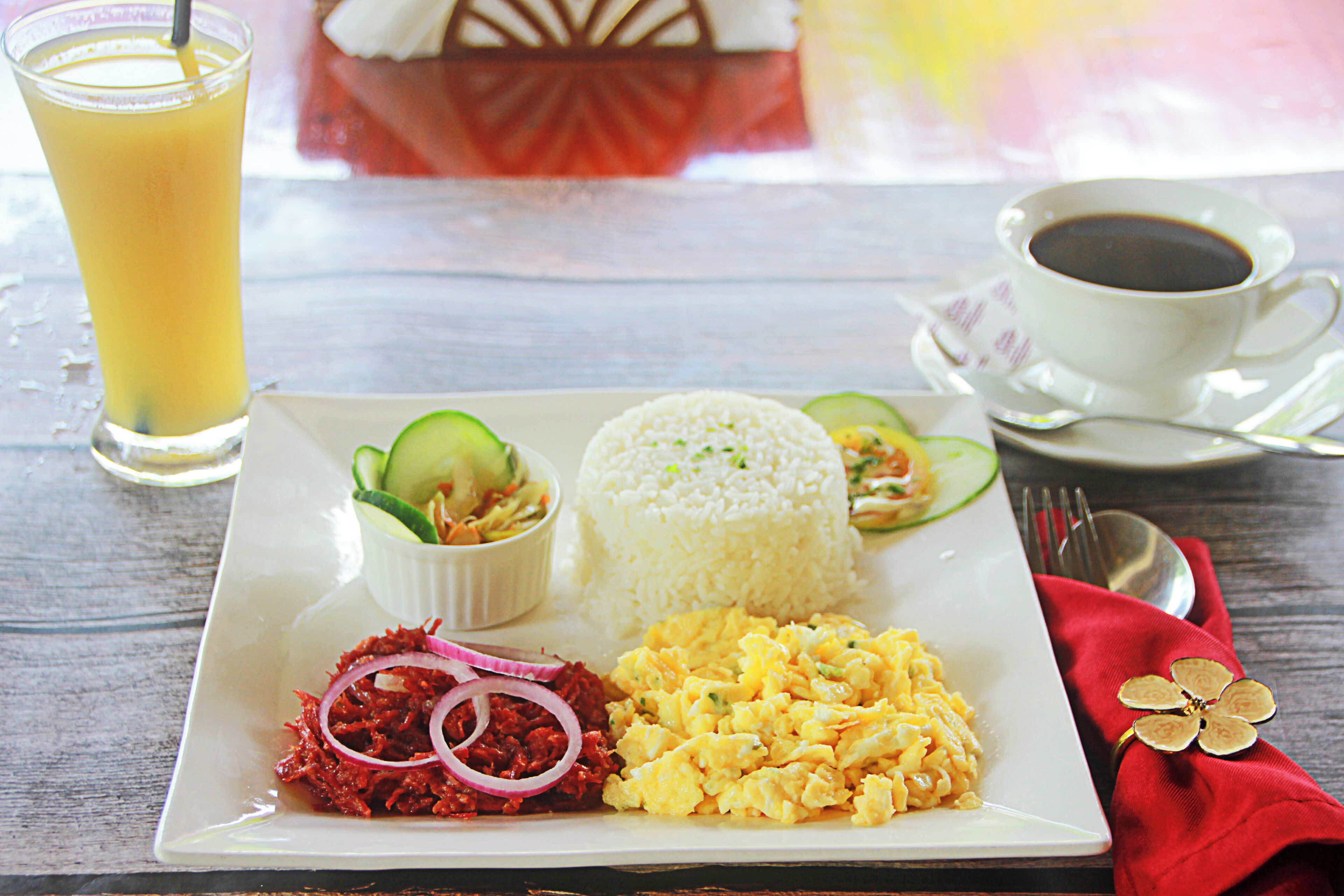 A plate of food with rice, scrambled eggs, and a side of vegetables.