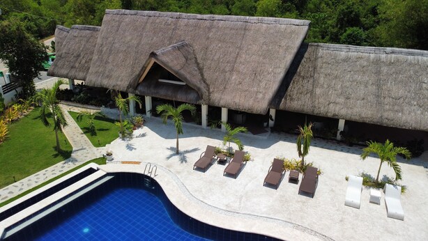 A resort with a pool, thatched-roof structures, and palm trees. - The Mayana Resort (Dauis)