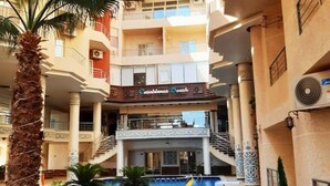 A hotel with a pool, multiple floors, and a sign for 'Casablanca Beach'. - Studio flat with balcony, free access to beach and pools at Casablanca Beach (Hurghada)