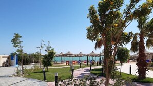 A resort area with a pool, outdoor seating, and palm trees. - Studio flat with balcony, free access to beach and pools at Casablanca Beach (Hurghada)