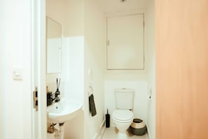 A bathroom with a white sink, a toilet, and a mirror. - Chic 2 Bedroom Apartment Salford Quays, the Lowry (Salford)