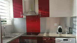 Una cocina compacta equipada con horno, lavadora y cafetera.