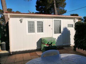 Un pequeño edificio blanco de una sola planta con dos ventanas, una puerta y un balconcito.