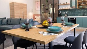 Un coin repas moderne avec une table en bois, des chaises noires et de la vaisselle de couleur turquoise.