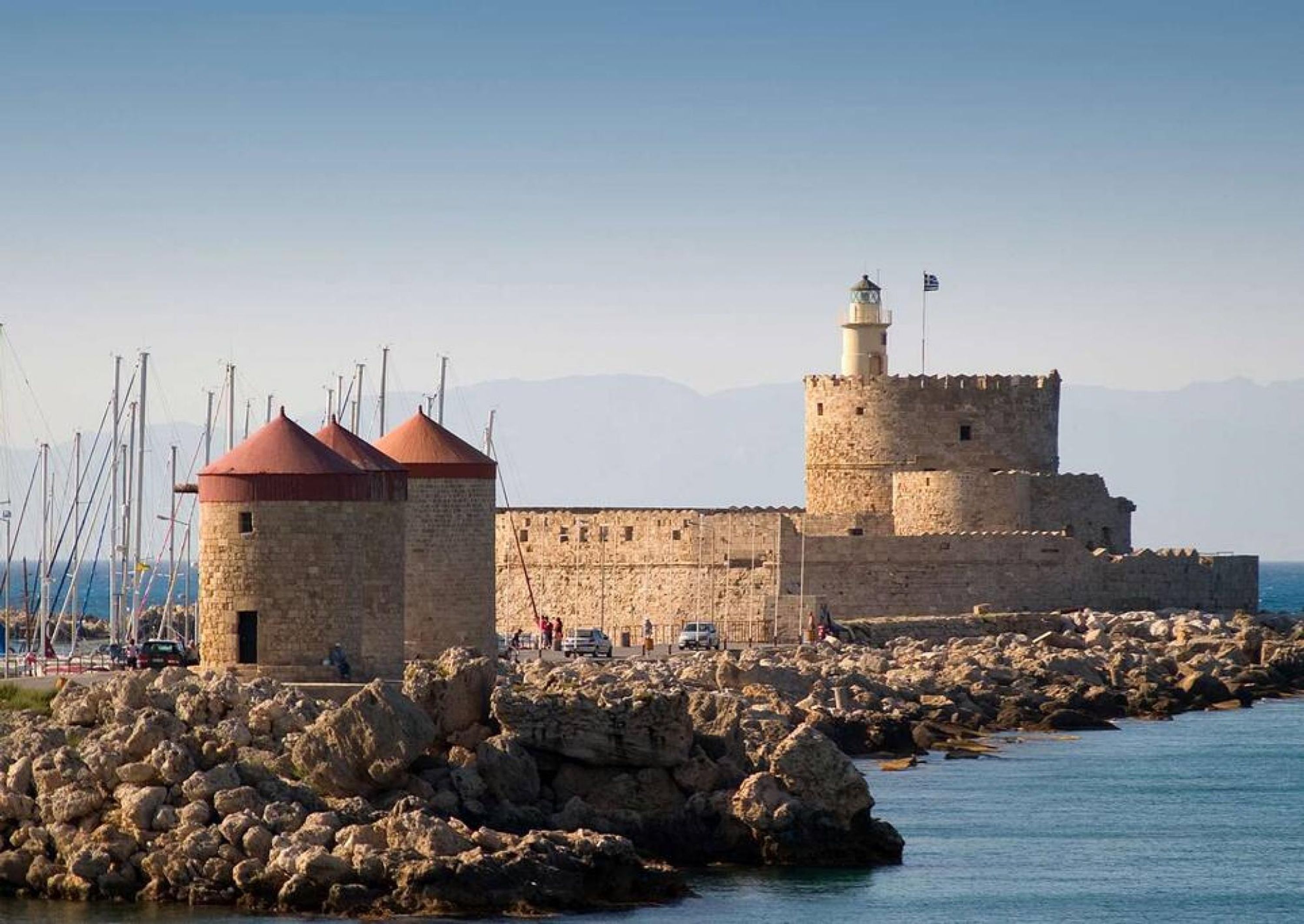Un fort côtier doté d’un phare, de murs en pierre et d’un terrain rocheux.