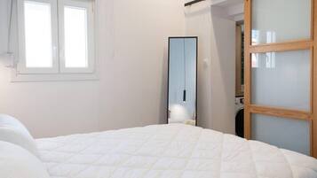 A bedroom with a bed, a wardrobe, and a window.