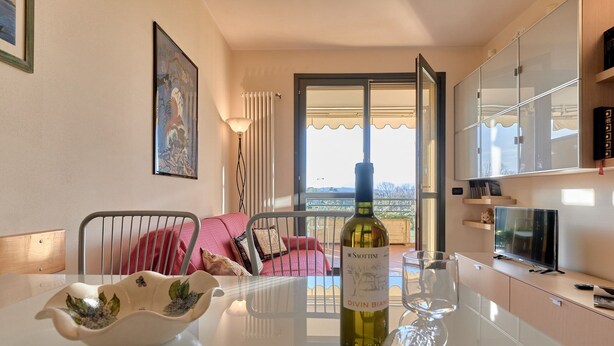 Una sala de estar moderna con una mesa de comedor, una botella de vino y un sofá.