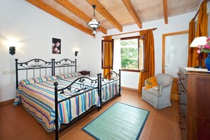 Relax in this serene bedroom with a large bed, wooden beams, and a dresser with a mirror.