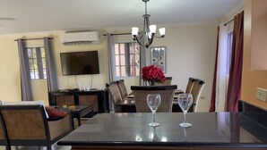 A dining area with a central island, wicker chairs, a table, and two wine glasses. - Montego Bay-Island Escape-Free-Shuttle (Montego Bay)