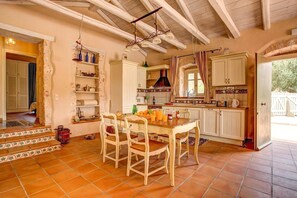 Traditional kitchen with central island, wooden top, and white cabinetry.