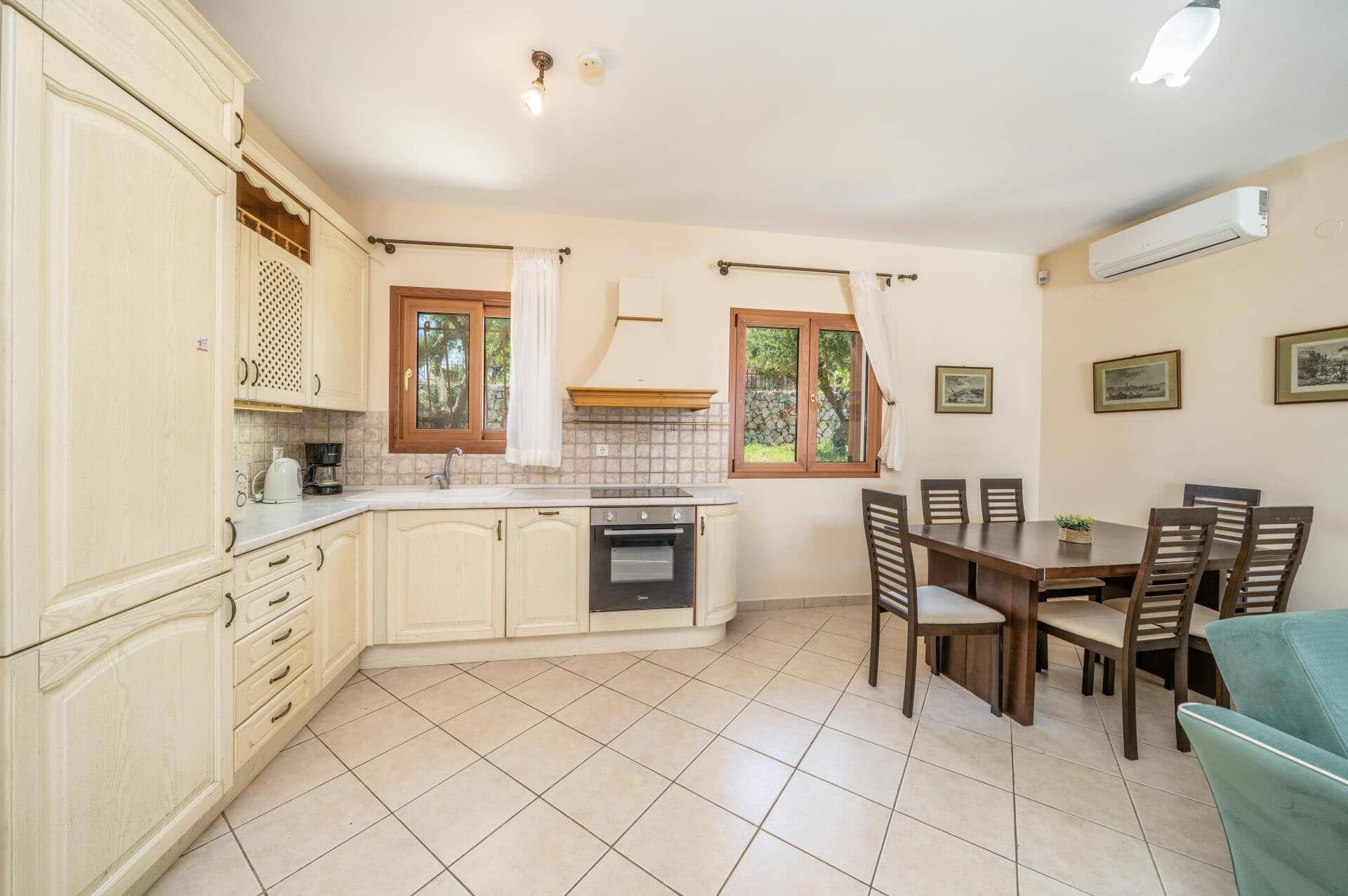 A kitchen with a dining area, featuring cabinets, a stove, and a table with chairs.
