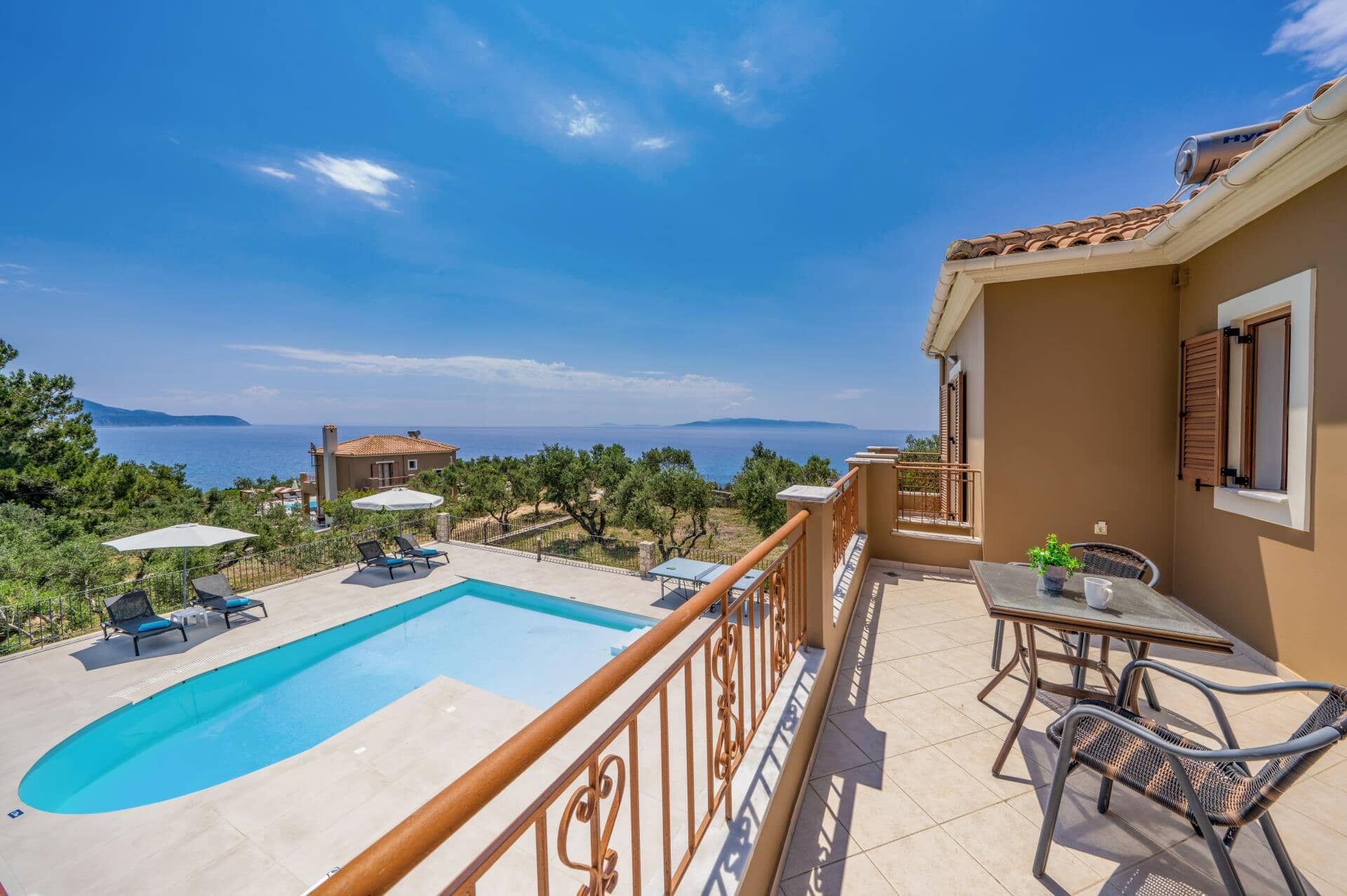 Un balcon avec une piscine, du mobilier d’extérieur et une vue sur la mer.