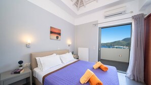 Une chambre d’hôtel comprenant un lit, une table de chevet, un tableau, une fenêtre avec vue et un appareil de climatisation.
