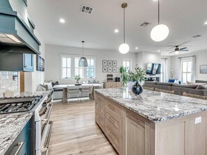 Una cocina moderna con una isla central, armarios de madera y una estufa grande.