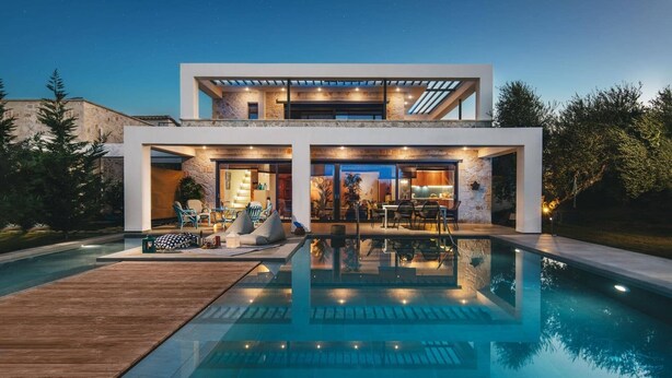 A modern two-story house with a swimming pool, outdoor seating, and a stone facade. - Villa Tiare 2 by Villa Plus (Ionian Islands)