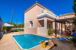 Un bâtiment à deux étages doté d’une piscine, d’un espace extérieur aménagé et d’un patio couvert.
