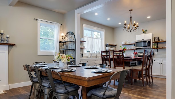 A spacious kitchen with a wooden dining table, modern appliances, and a chandelier. - The Sterling- walk to everything Luray has to offer! Chef available (Luray)