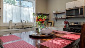 A kitchen with a wooden island, stainless steel appliances, and a window with sheer curtains. - The Sterling- walk to everything Luray has to offer! Chef available (Luray)