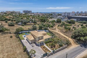 Un immobile residenziale con vialetto lastricato, patio coperto e vista sulla zona circostante.
