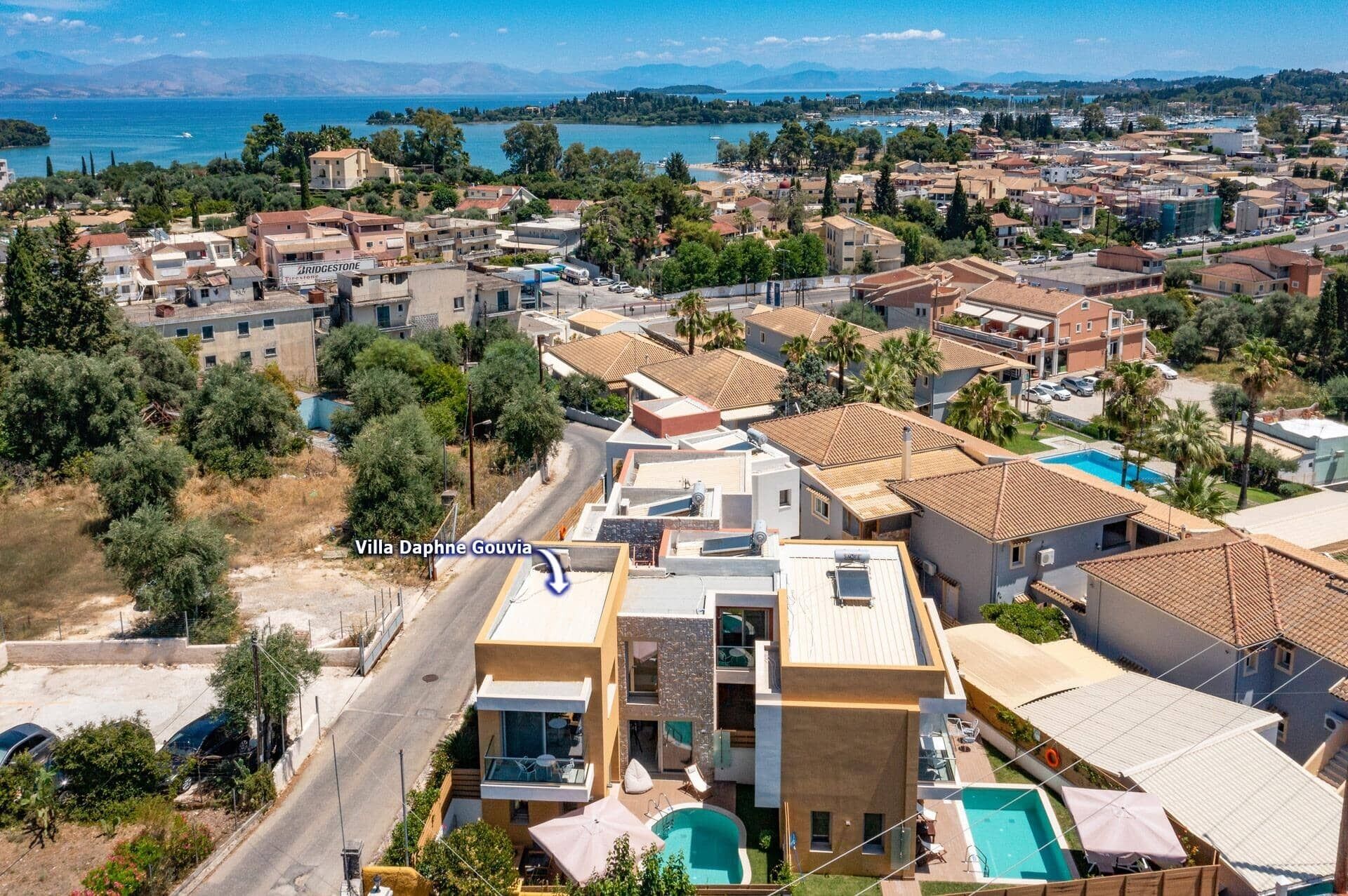 Une villa moderne avec piscine, située dans une ville côtière et offrant une vue sur la mer.