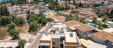 Une villa moderne avec piscine, située dans une ville côtière et offrant une vue sur la mer.