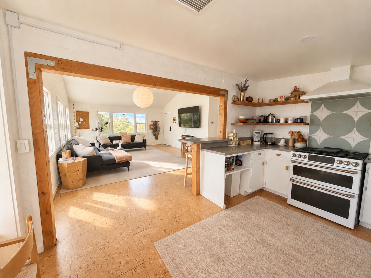 Een moderne keuken met een centraal eiland, witte kastjes en een inbouwoven.