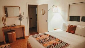 A bedroom with a bed, bedside table, lamp, and a mirror. - Joshua Tree - Under the Stars-Pool, Spa & Fire pit (Yucca Valley)