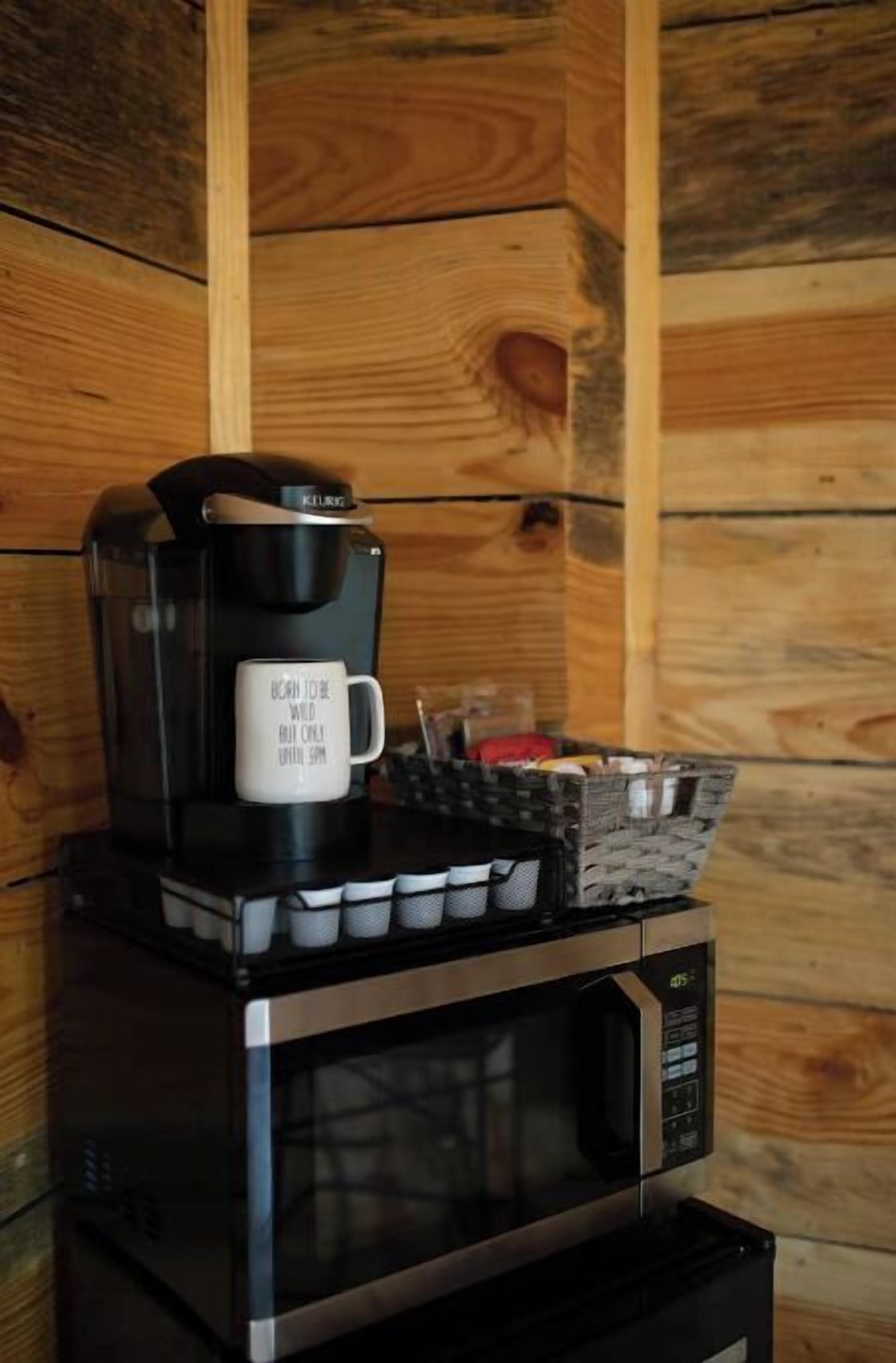 Una cafetera y un microondas sobre una superficie de madera.
