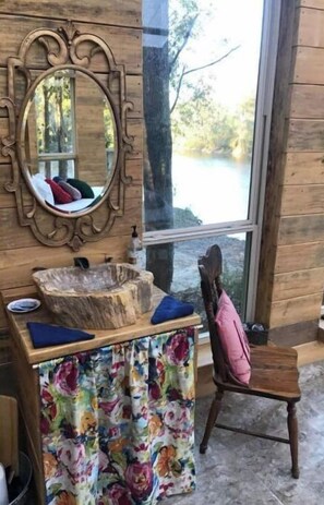 Cozy cabin-style room with a large mirror, wooden table, and comfortable chair.