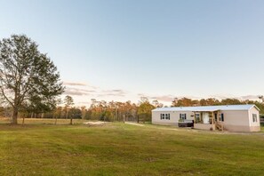 A single-story mobile home with a flat roof, a front porch, and a small attached garage.
