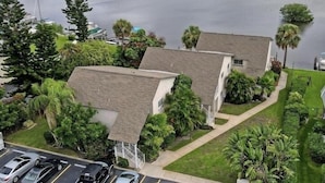 A waterfront property with a parking lot, two-story buildings, and a view of the water.