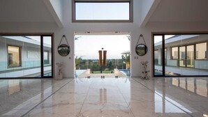 A spacious lobby with a high ceiling, large windows, and a marble floor. - Casa de Campo’s Ultimate Group Villa Pool, Cinema & Pickleball (La Romana)