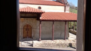 A courtyard with a tiled roof, a wooden door, and stone walls. - Hotel San Martino (Lena)